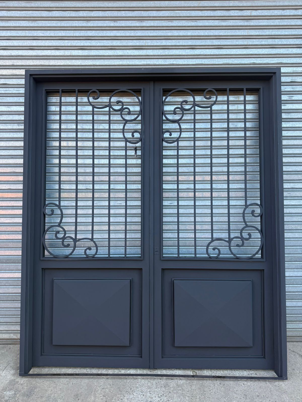 Puerta doble de hierro con diseño artístico instalada — Ramos Mejía, Zona Oeste